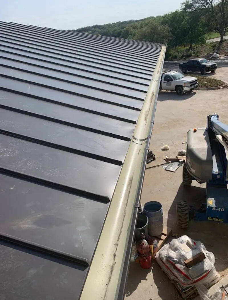 Standing seam panel and gutter detail on a metal roofing jobsite in Clayton